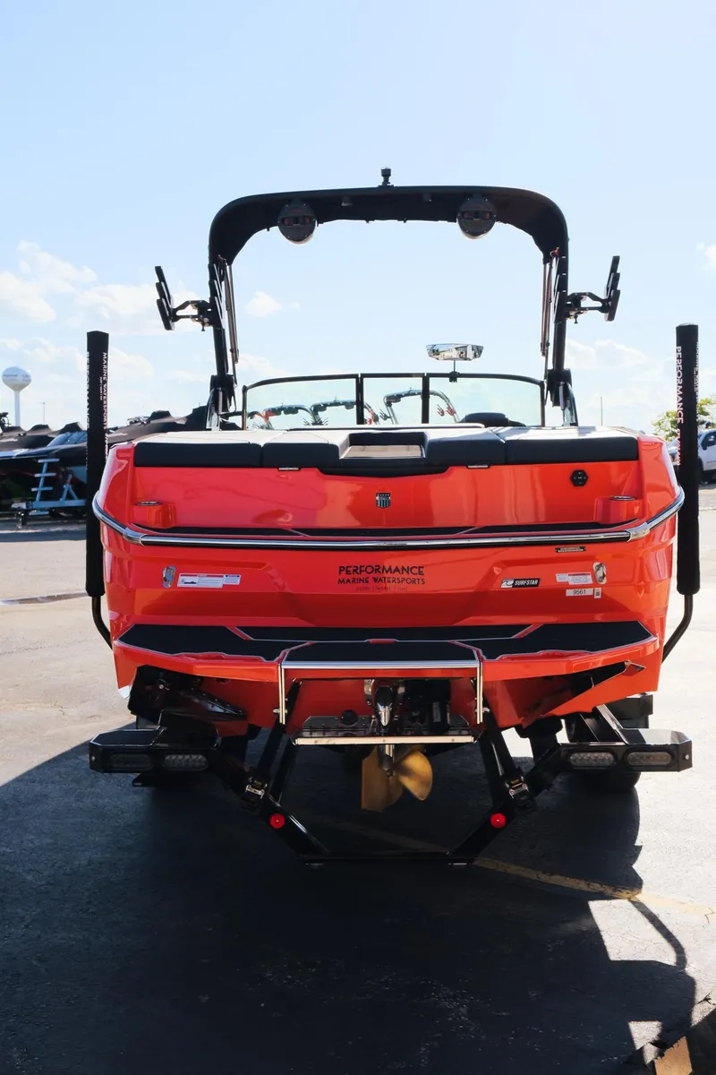 Slide: The Image of 2025 MasterCraft NXT24 boat, rear view, vibrant orange color, parked outdoors. - 6