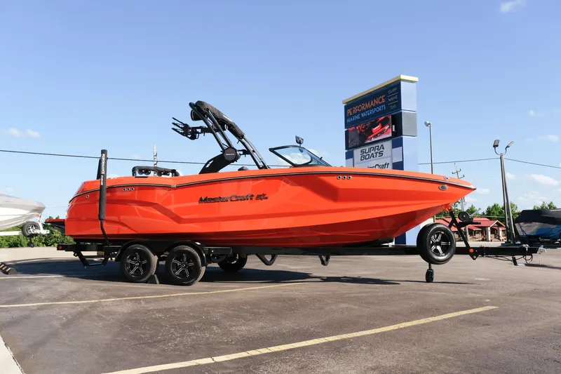 Slide: The Image of 2025 MasterCraft NXT24 boat in vibrant orange on a trailer at a dealership. - 8