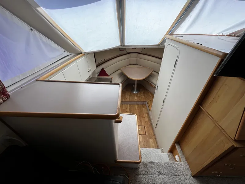 Slide: The Image of Interior of 1996 Carver 325 Aft Cabin with seating and table, featuring wood accents. - 24
