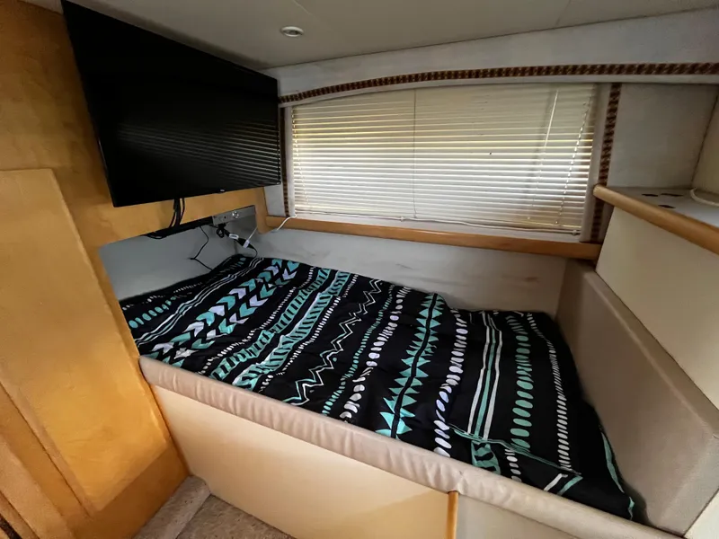 Slide: The Image of 1996 Carver 325 Aft Cabin interior with bed, TV, and window blinds. - 33