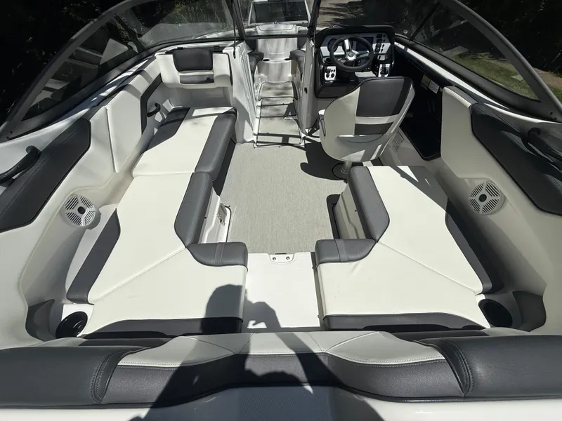Slide: The Image of 2022 Yamaha Boats AR210 interior with spacious seating and modern dashboard. - 11