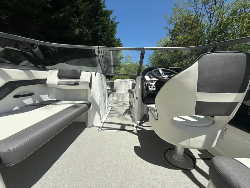 Slide: The Image of 2022 Yamaha AR210 boat interior with seating and steering, under clear blue sky. - 12