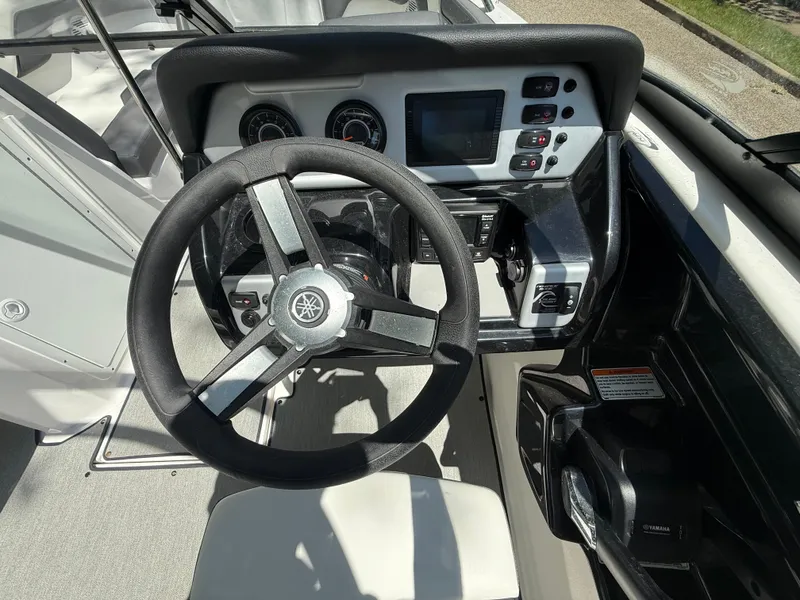 Slide: The Image of 2022 Yamaha AR210 boat dashboard with steering wheel and control panel. - 14