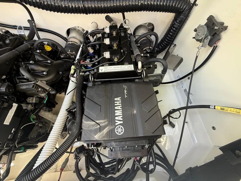 Slide: The Image of Engine compartment of a 2022 Yamaha Boats AR210, showcasing intricate wiring and components. - 31