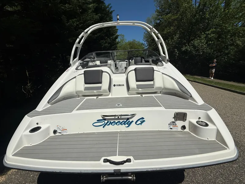 Slide: The Image of 2022 Yamaha Boats AR210, rear view, on a sunny day with trees in the background. - 5