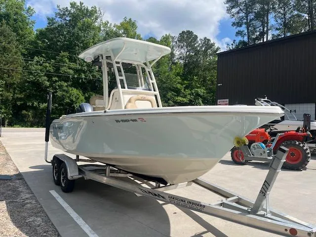 Slide: The Image of 2020 Key West 219 FS boat on trailer, parked outdoors near trees and a building. - 5