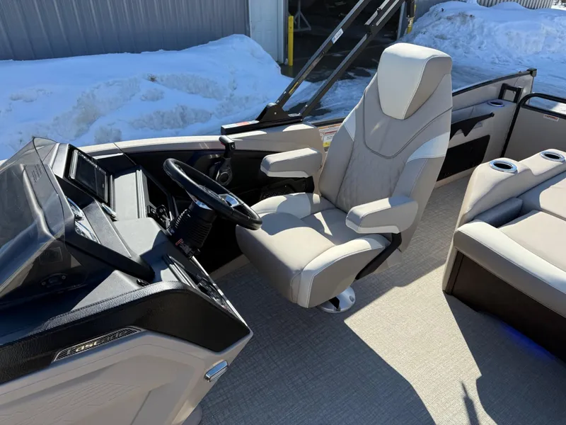 Slide: The Image of 2025 Tahoe Pontoon Cascade Versatile Rear Lounger interior with captain's chair and steering console. - 7