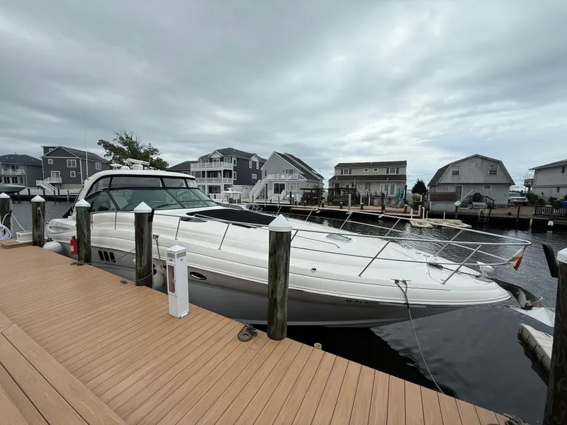 Slide: The Image of 2006 Sea Ray 52 Sundancer yacht docked at a marina with overcast skies. - 0