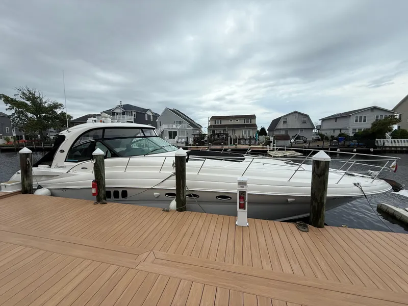 Slide: The Image of 2006 Sea Ray 52 Sundancer yacht docked at a marina with overcast skies. - 1