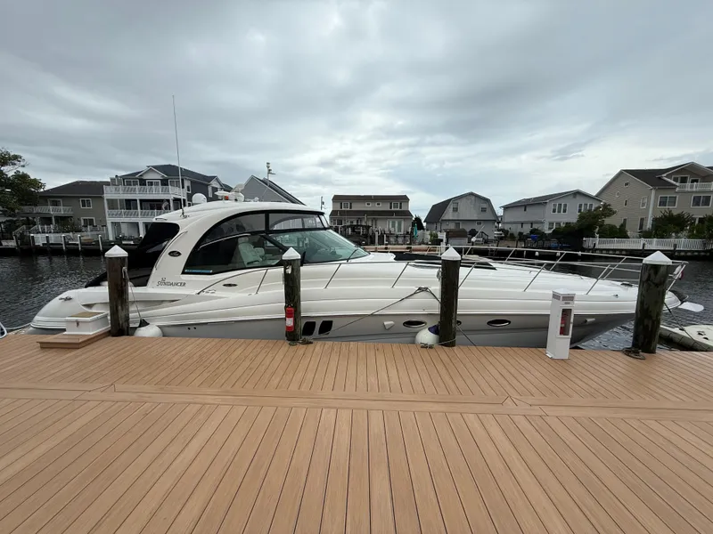 Slide: The Image of 2006 Sea Ray 52 Sundancer yacht docked at a marina with overcast skies. - 2