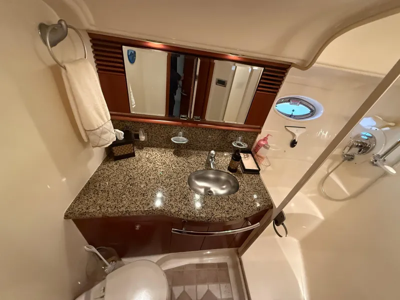 Slide: The Image of Luxurious bathroom in 2006 Sea Ray 52 Sundancer yacht with granite countertop and porthole window. - 29