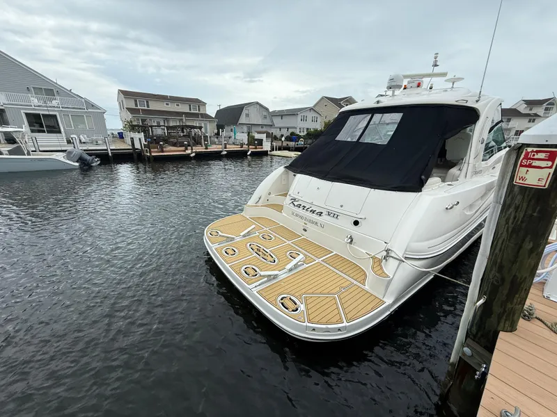 Slide: The Image of 2006 Sea Ray 52 Sundancer yacht docked in a marina, featuring a spacious deck. - 3