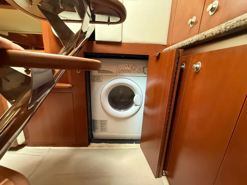 Slide: The Image of Laundry area inside 2006 Sea Ray 52 Sundancer yacht with wooden cabinetry. - 35
