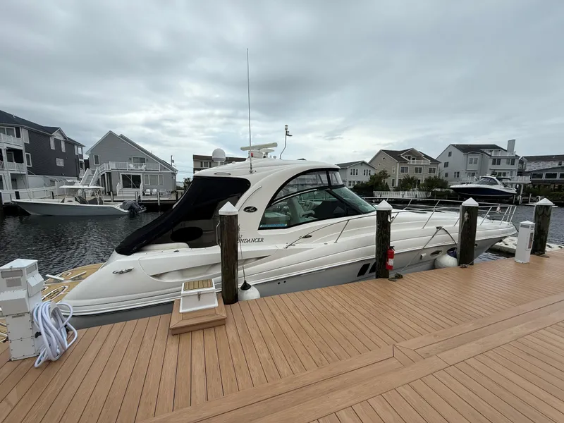 Slide: The Image of 2006 Sea Ray 52 Sundancer yacht docked at a marina with waterfront homes. - 4