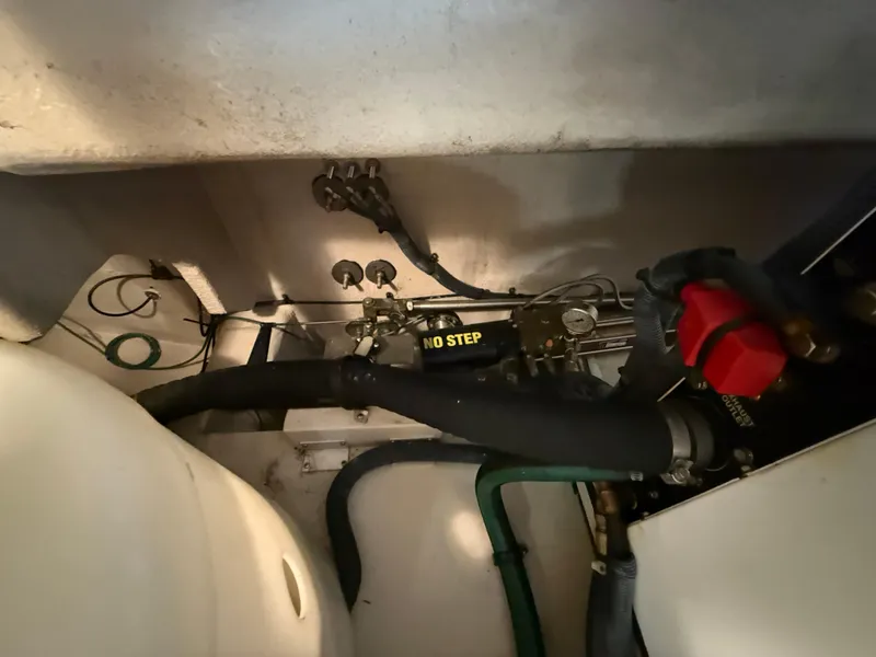 Slide: The Image of Engine compartment of 2006 Sea Ray 52 Sundancer with visible hoses and "No Step" label. - 47