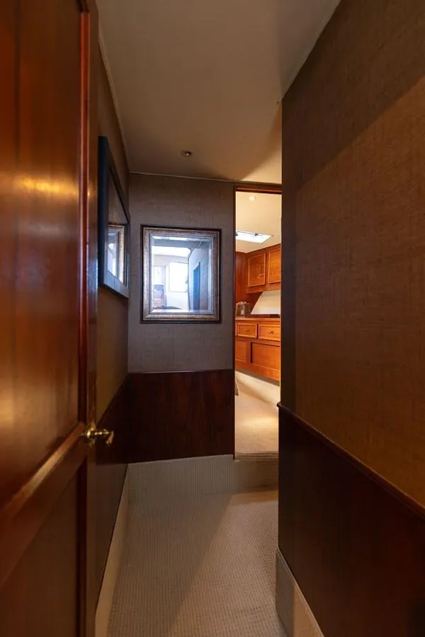 Slide: The Image of Interior hallway of a 1987 Ocean Yachts Convertible, featuring wooden paneling and carpeted flooring. - 12