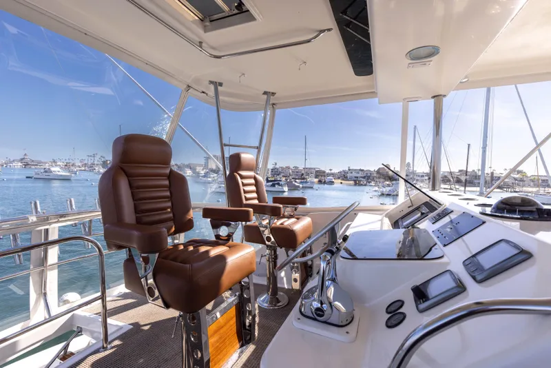 Slide: The Image of 1987 Ocean Yachts Convertible cockpit with leather seats and control panel, overlooking marina. - 3