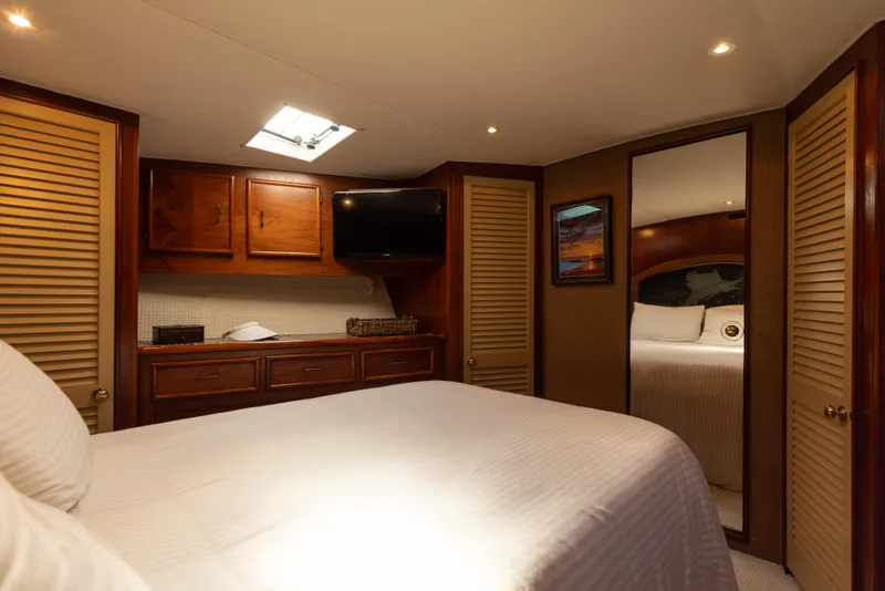 Slide: The Image of Luxurious cabin interior of a 1987 Ocean Yachts Convertible, featuring wood accents and cozy bedding. - 9