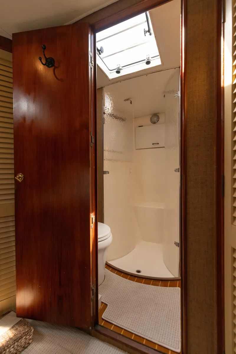 Slide: The Image of 1987 Ocean Yachts Convertible bathroom with wooden door and skylight. - 11