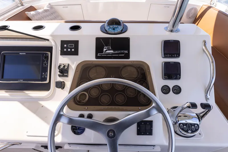 Slide: The Image of 1987 Ocean Yachts Convertible helm with steering wheel, navigation instruments, and control panel. - 19