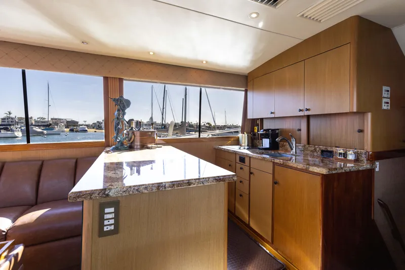 Slide: The Image of Interior of 1987 Ocean Yachts Convertible, featuring a modern kitchen with marina view. - 2