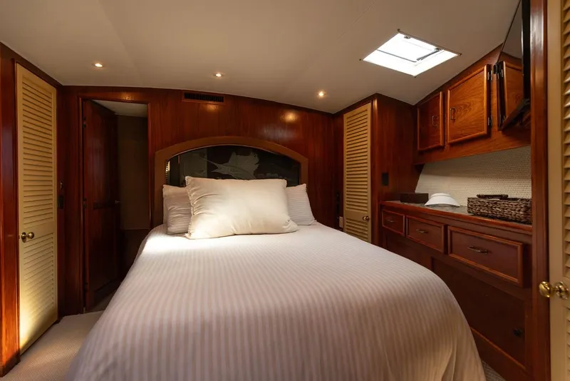 Slide: The Image of Luxurious bedroom interior of 1987 Ocean Yachts Convertible, featuring wood paneling and cozy bedding. - 8