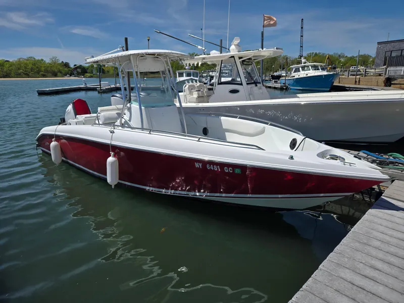 Slide: The Image of 2004 Baja 250 Sportfish boat docked, red and white design, calm water, sunny day. - 0