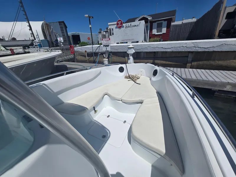 Slide: The Image of 2004 Baja 250 Sportfish boat with white seating, docked at a marina. - 1
