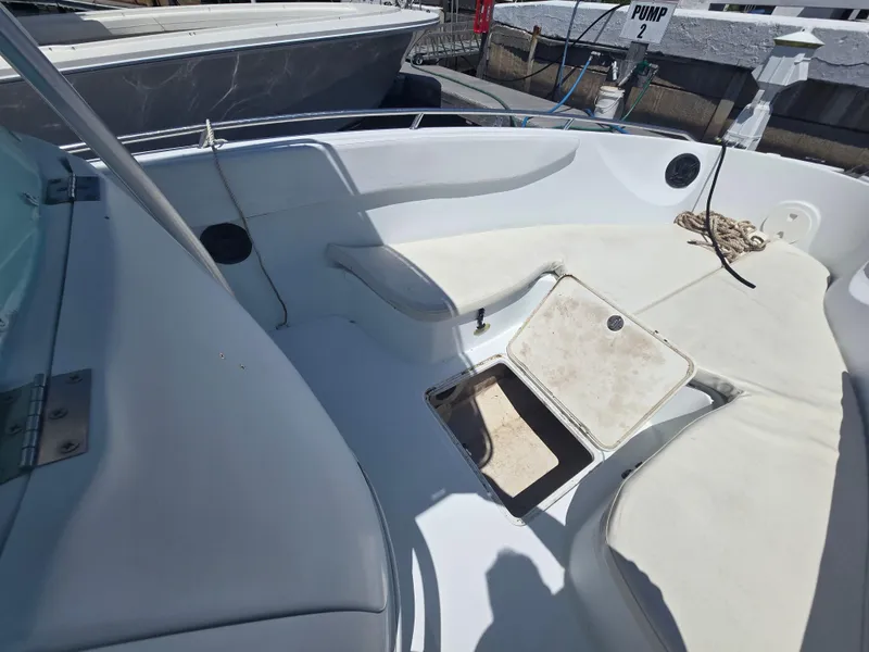 Slide: The Image of 2004 Baja 250 Sportfish boat interior with open storage compartment and seating area. - 2