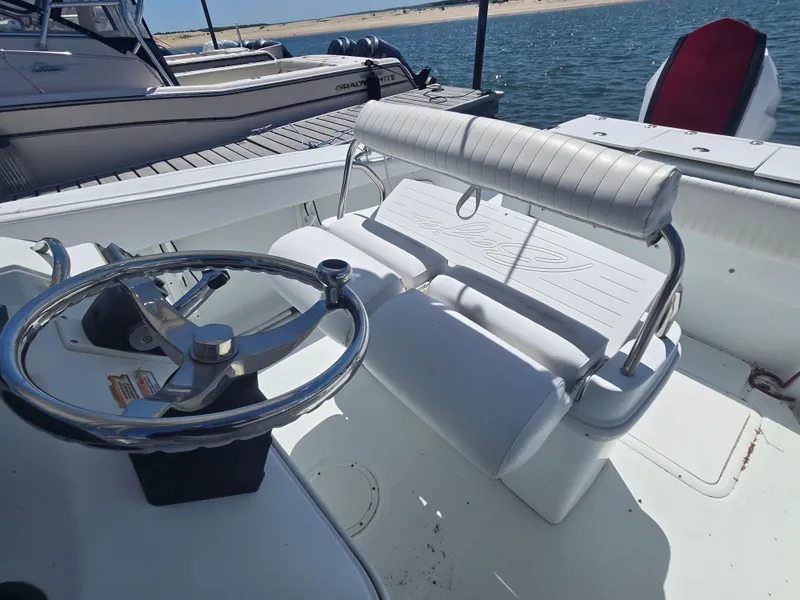 Slide: The Image of 2004 Baja 250 Sportfish boat interior with steering wheel and seating, docked by the water. - 5