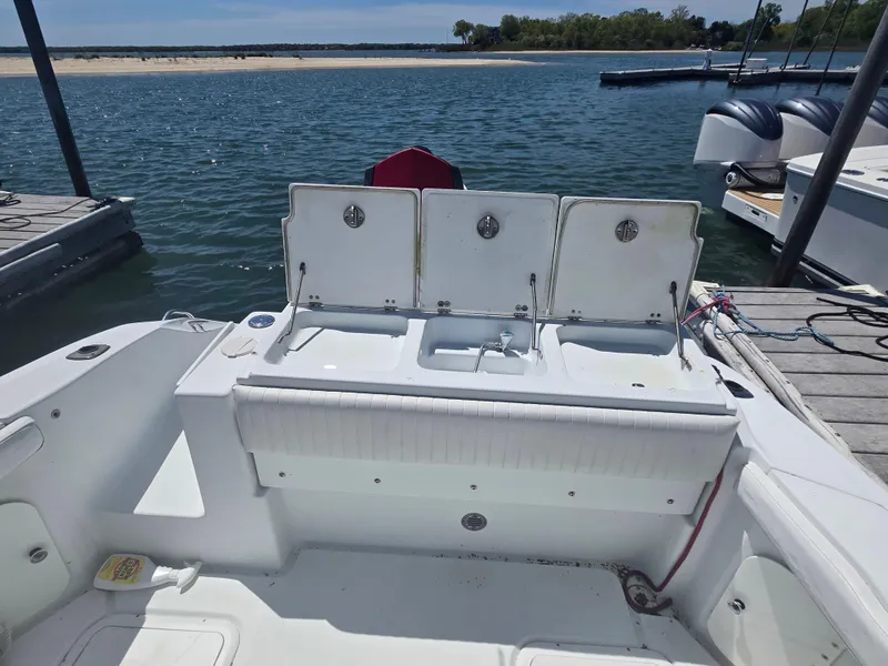 Slide: The Image of 2004 Baja 250 Sportfish boat docked by the water, featuring open storage compartments. - 9