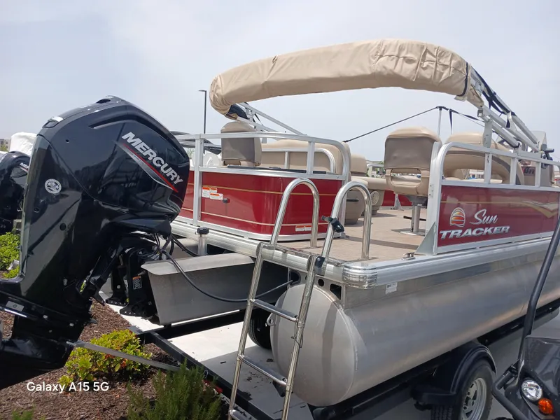 Slide: The Image of 2023 Sun Tracker 18BASSBUGGY pontoon boat with Mercury engine, beige canopy, and red accents. - 3