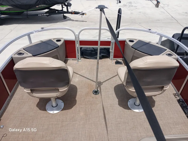 Slide: The Image of 2023 Sun Tracker 18BASSBUGGY pontoon boat interior with two beige seats and red accents. - 8