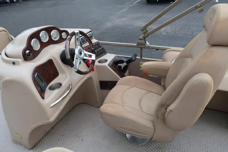 Slide: The Image of 2008 Godfrey SAN PAN 2500 RE boat interior with beige captain's chair and control panel. - 13