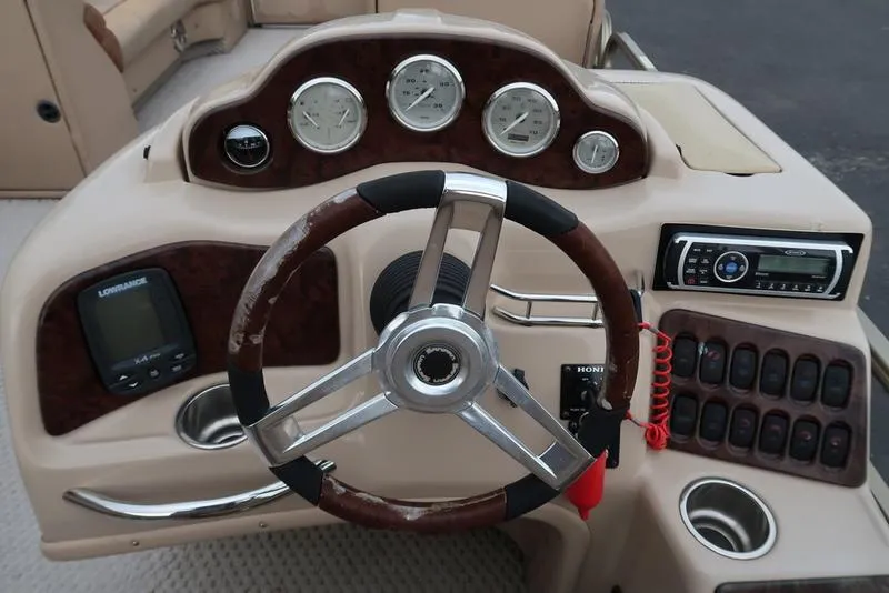 Slide: The Image of 2008 Godfrey SAN PAN 2500 RE boat dashboard with steering wheel and control panel. - 14