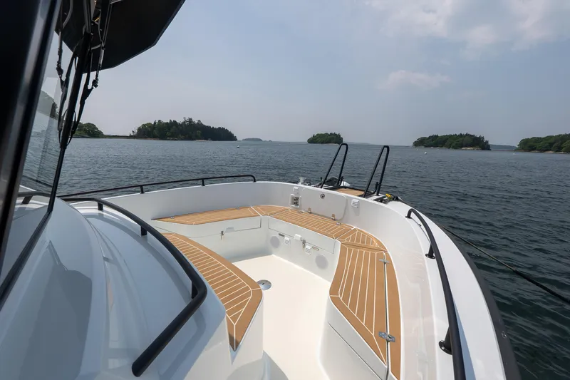 Slide: The Image of 2025 Targa 32 GT boat cruising on a serene lake with distant islands. - 20