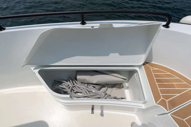 Slide: The Image of Open storage compartment on 2025 Targa 32 GT boat, containing rope and cover. - 23