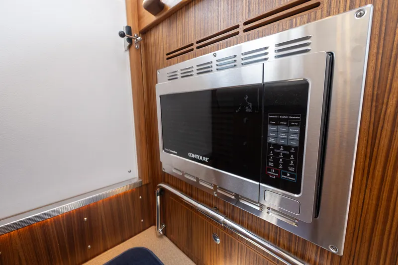 Slide: The Image of Built-in microwave in 2025 Targa 32 GT boat interior, featuring wood paneling. - 33