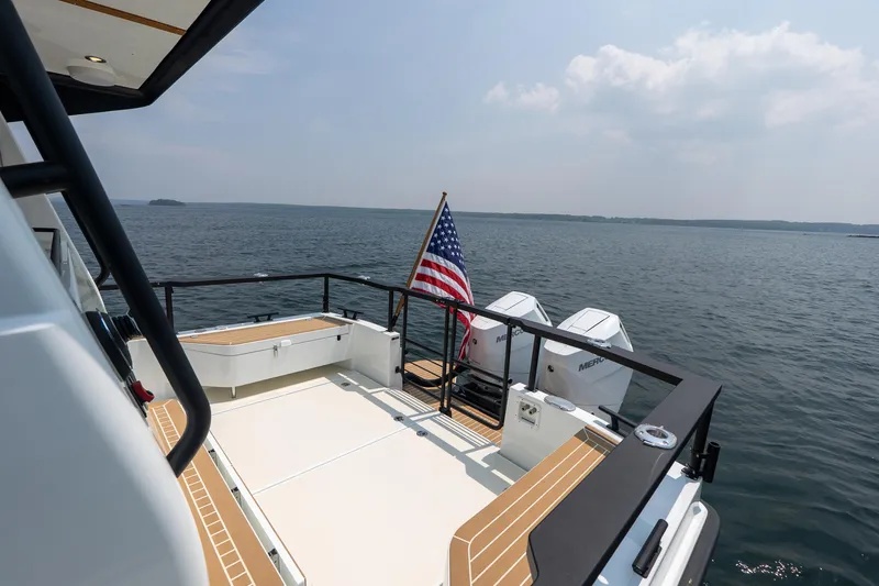 Slide: The Image of 2025 Targa 32 GT boat deck with American flag, overlooking serene ocean view. - 4