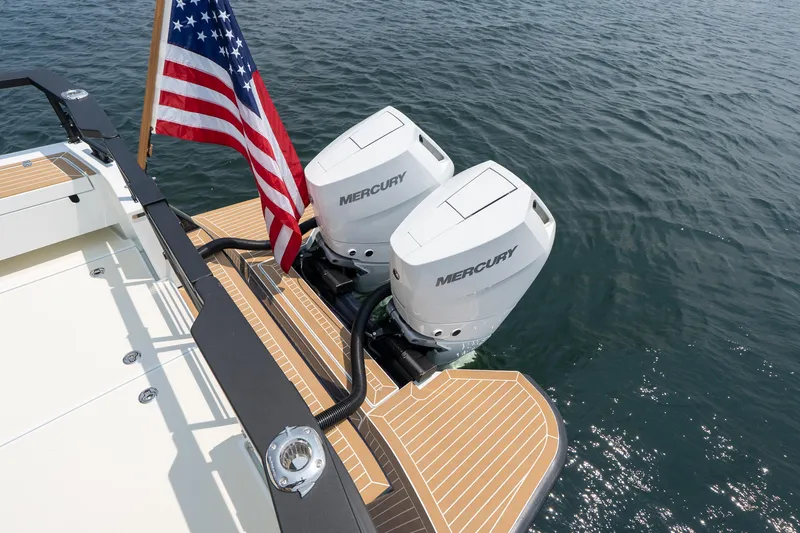 Slide: The Image of 2025 Targa 32 GT boat with dual Mercury engines and American flag on water. - 5