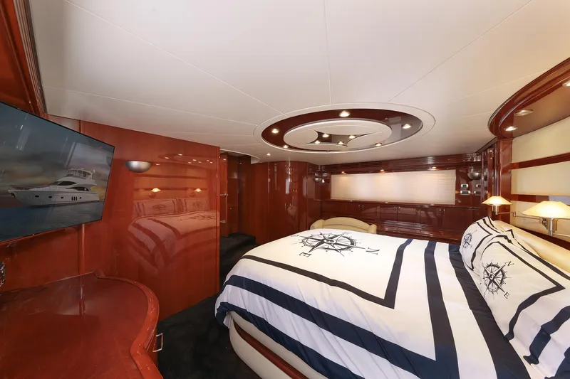 Slide: The Image of Luxurious 2007 Marquis 65 yacht bedroom with elegant wood paneling and nautical-themed bedding. - 11