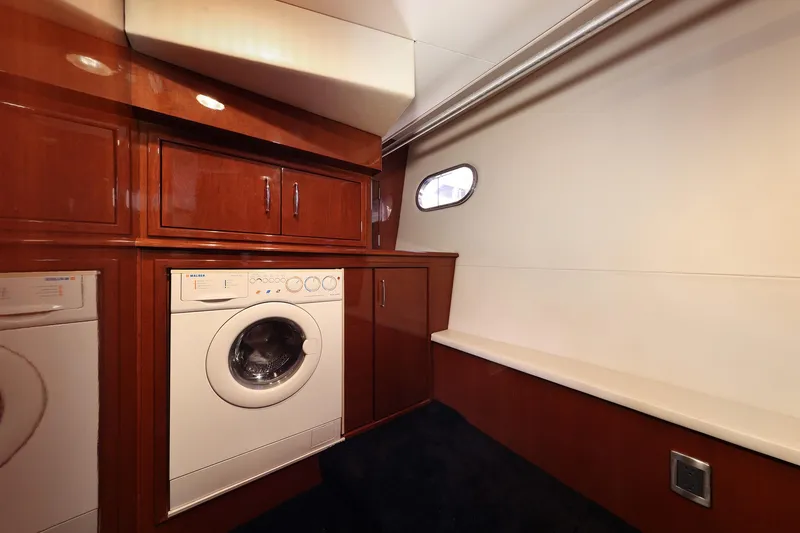 Slide: The Image of Laundry area in 2007 Marquis 65 yacht with washer, dryer, and storage cabinets. - 12