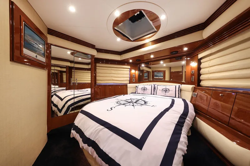 Slide: The Image of Luxurious 2007 Marquis 65 yacht bedroom with elegant wood finishes and nautical-themed bedding. - 15