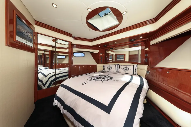 Slide: The Image of Luxurious bedroom interior of 2007 Marquis 65 yacht with elegant wood finishes and nautical bedding. - 16