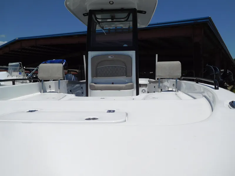 Slide: The Image of 2025 Sea Hunt BX 25 FS boat, white deck, center console, docked under a blue-roofed shelter. - 3
