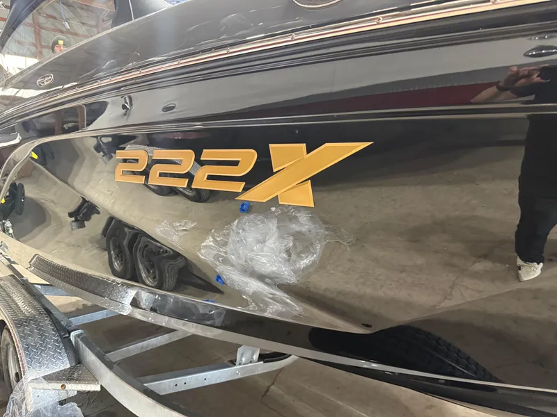 Slide: The Image of 2025 Yamaha Boats 222XD, sleek black exterior with gold "222X" lettering. - 10