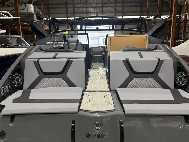 Slide: The Image of 2025 Yamaha Boats 222XD interior with modern seating and sleek design in a warehouse setting. - 3