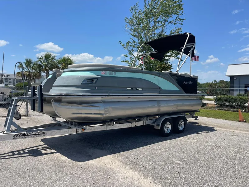 Slide: The Image of 2020 Silver Wave 2210 SW5 L pontoon boat on trailer, parked outdoors under clear sky. - 12