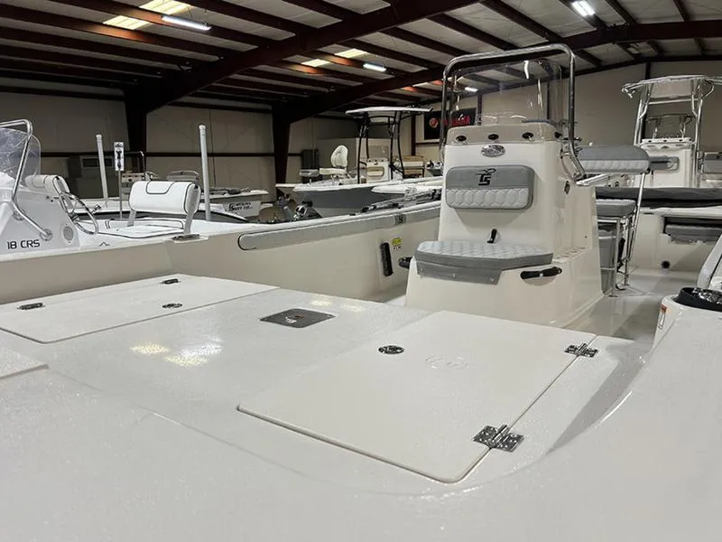 Slide: The Image of 2025 Carolina Skiff 21 LS boat interior, showcasing seating and storage in a showroom setting. - 2