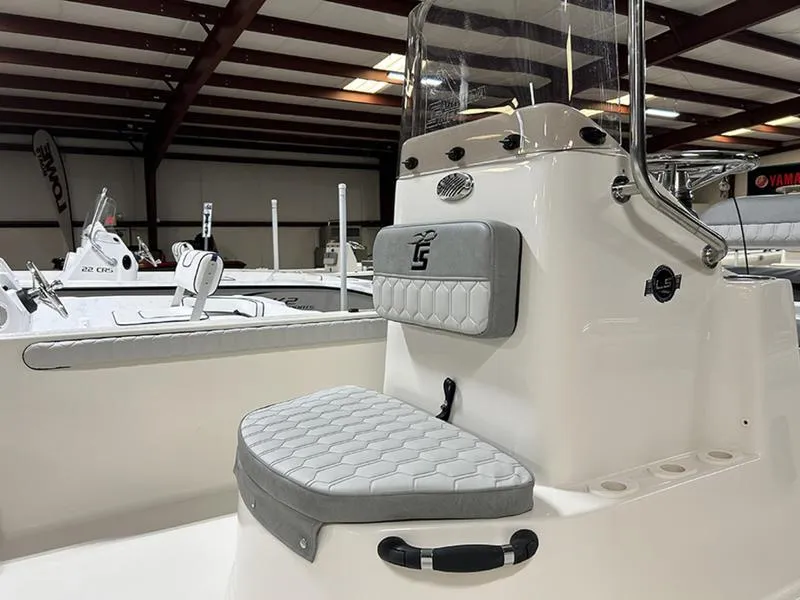 Slide: The Image of 2025 Carolina Skiff 21 LS boat interior with cushioned seating and control panel in a showroom. - 3